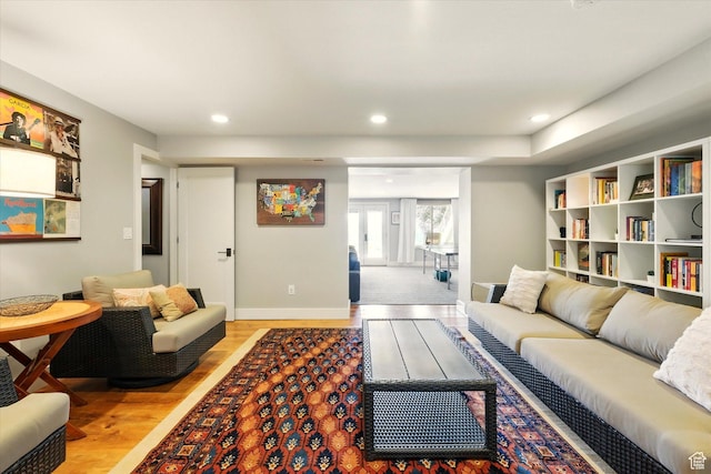 living room with light wood finished floors, recessed lighting, and baseboards