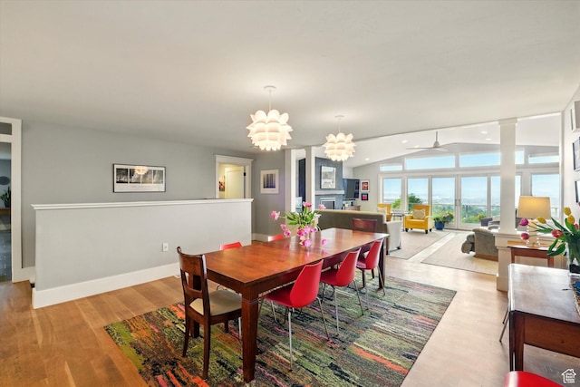 dining area featuring vaulted ceiling, a ceiling fan, light wood finished floors, and baseboards