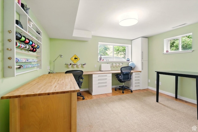 office area featuring plenty of natural light, light wood-style flooring, and built in study area