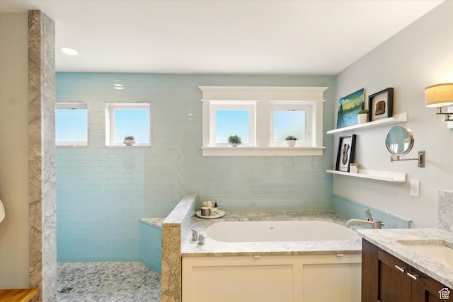 bathroom with a bath, walk in shower, and vanity