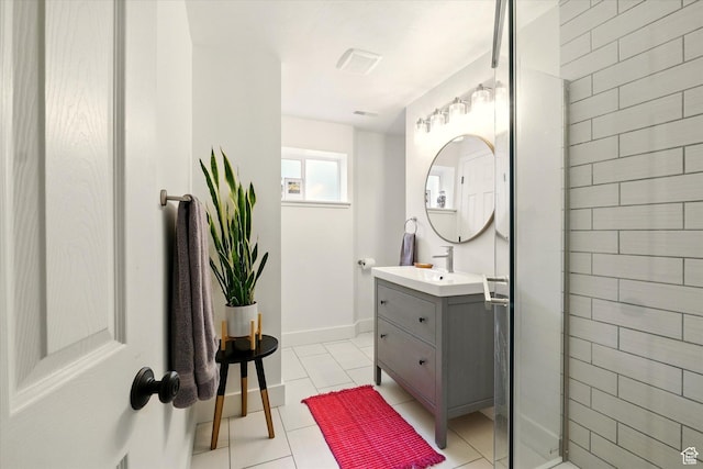 bathroom featuring a stall shower, vanity, tile patterned floors, and baseboards