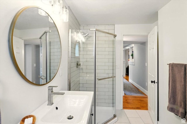 bathroom with a shower stall, tile patterned flooring, and vanity