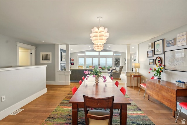 dining room featuring light wood-style flooring, baseboards, and a chandelier