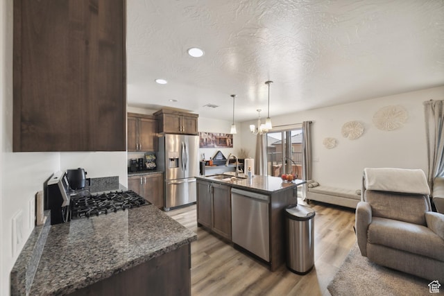 5849 S Firebird Way, St George, UT 84790 - kitchen with stainless steel appliances, a sink, open floor plan, dark brown cabinets, and recessed lighting