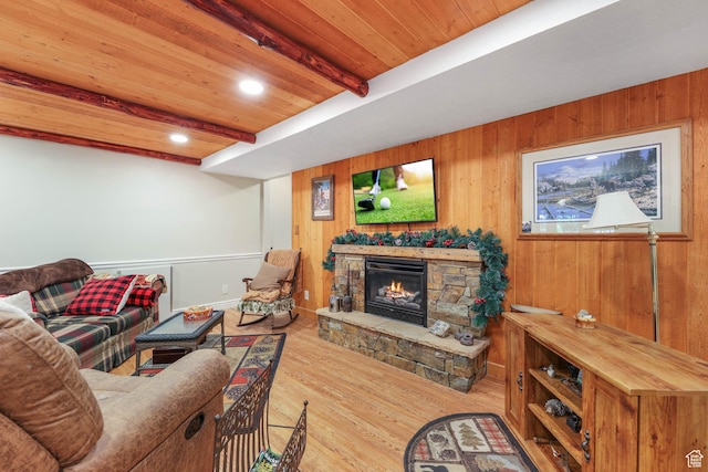 living area featuring wood finished floors, wooden ceiling, beam ceiling, a fireplace, and wood walls