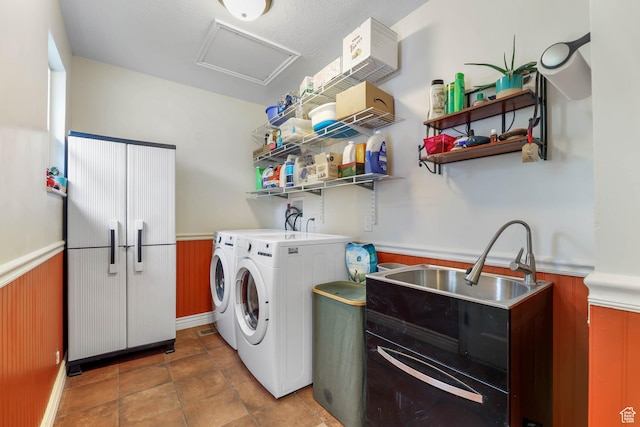 laundry room featuring wainscoting, washing machine and clothes dryer, attic access, and wood walls