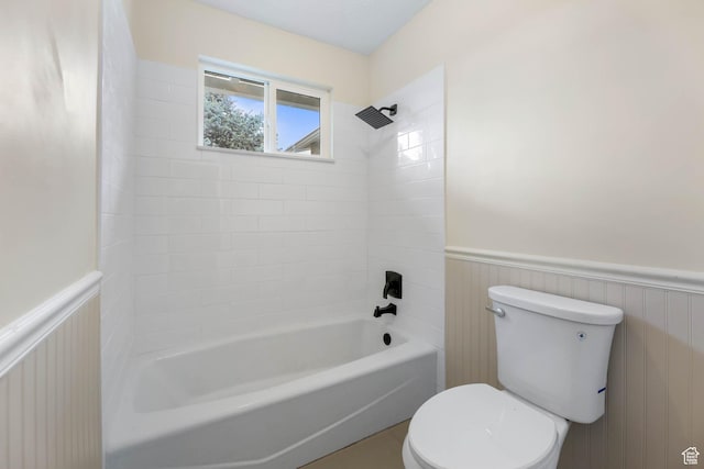 full bathroom featuring a wainscoted wall, toilet, and bathing tub / shower combination