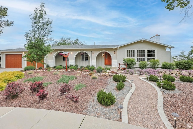 single story home with an attached garage, a chimney, stucco siding, and concrete driveway