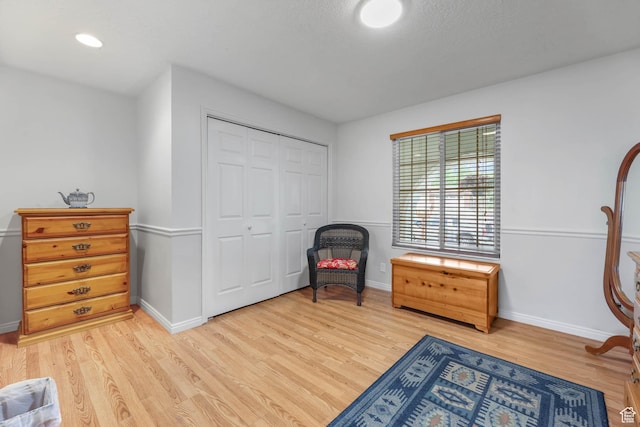 living area with light wood-style flooring and baseboards