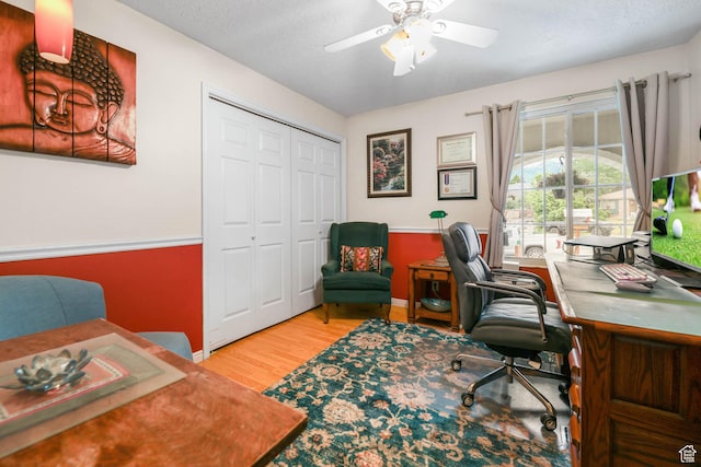 office space with baseboards, wood finished floors, and a ceiling fan