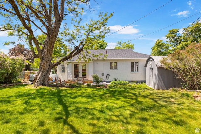 rear view of property featuring french doors, an outdoor structure, a shed, and brick siding