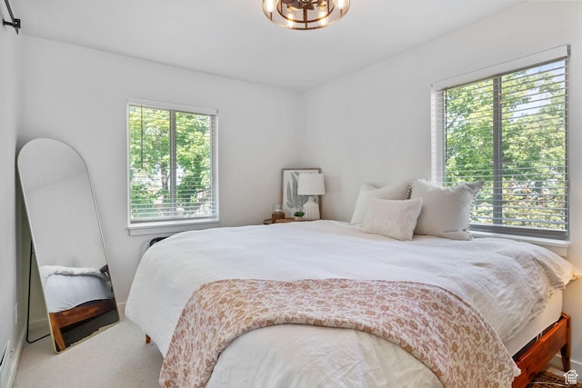 bedroom with carpet flooring and a chandelier