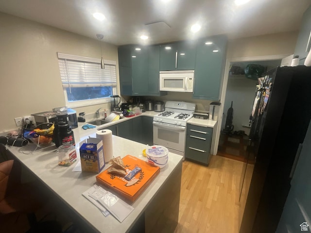 595 N 1200th St E, Lehi, UT 84043 - kitchen featuring white appliances, light countertops, a sink, light wood-style flooring, and a peninsula