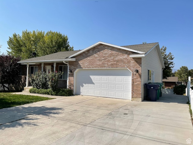 595 N 1200th St E, Lehi, UT 84043 - ranch-style home with brick siding, a garage, driveway, and covered porch