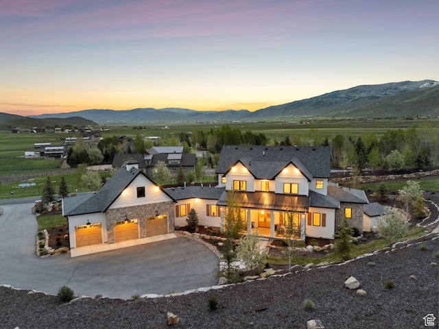 1677 Lambert Ln, Kamas, UT 84036 - view of front of home with driveway, an attached garage, a mountain view, and stone siding