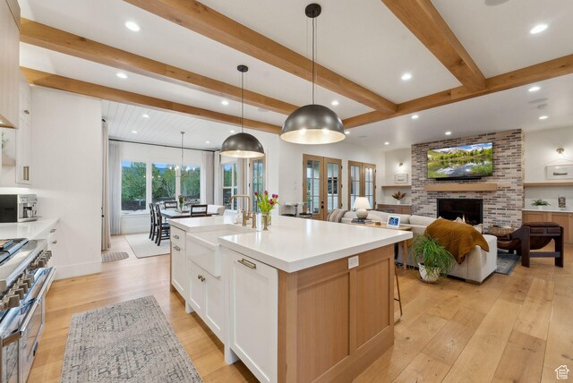 1677 Lambert Ln, Kamas, UT 84036 - kitchen with a sink, recessed lighting, range with two ovens, beamed ceiling, and light wood-style flooring