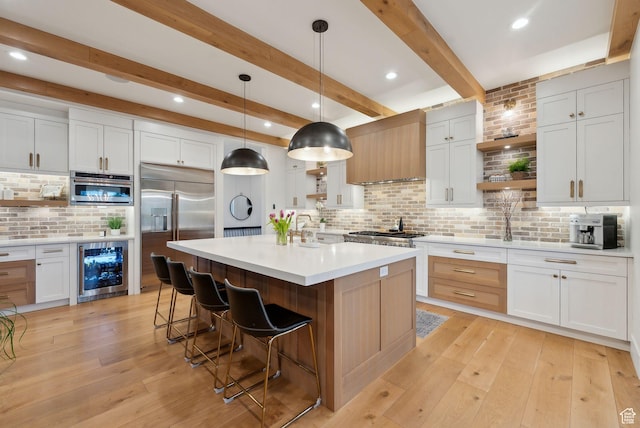 1677 Lambert Ln, Kamas, UT 84036 - kitchen with open shelves, stainless steel appliances, beverage cooler, a kitchen bar, and backsplash