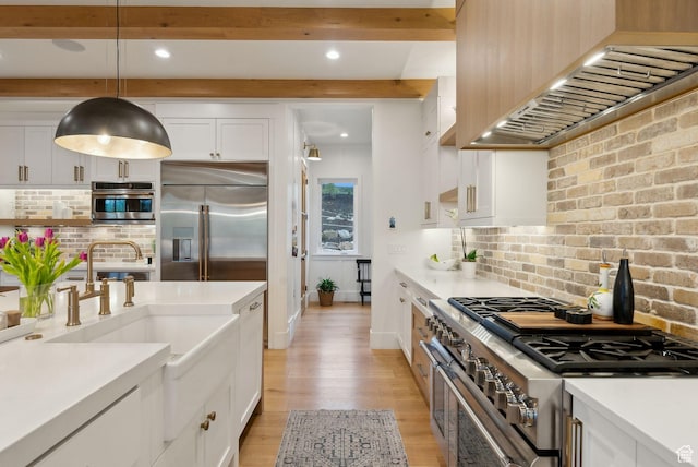 1677 Lambert Ln, Kamas, UT 84036 - kitchen featuring high end appliances, wall chimney range hood, light wood-style flooring, white cabinets, and backsplash