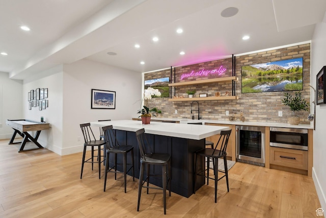1677 Lambert Ln, Kamas, UT 84036 - indoor wet bar featuring beverage cooler, stainless steel microwave, recessed lighting, light wood-style flooring, and baseboards