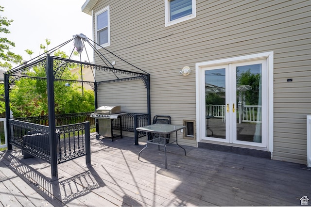 wooden terrace with french doors, a gazebo, and a grill