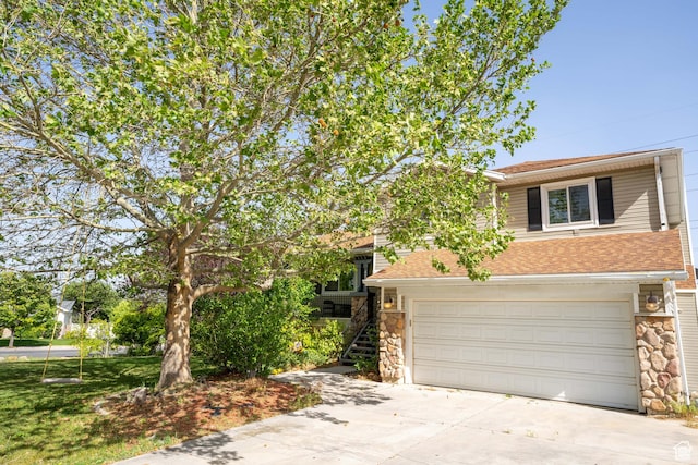 view of front of house featuring stone siding, concrete driveway, roof with shingles, stairs, and an attached garage