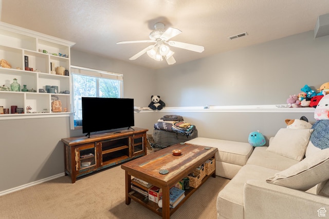living area featuring light colored carpet, ceiling fan, and baseboards