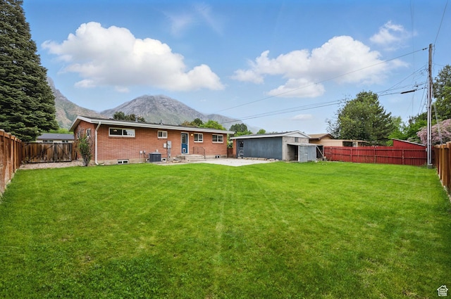 2925 N 220 E, Provo, UT 84604 - rear view of house with a mountain view, brick siding, a patio area, an outbuilding, and central air condition unit