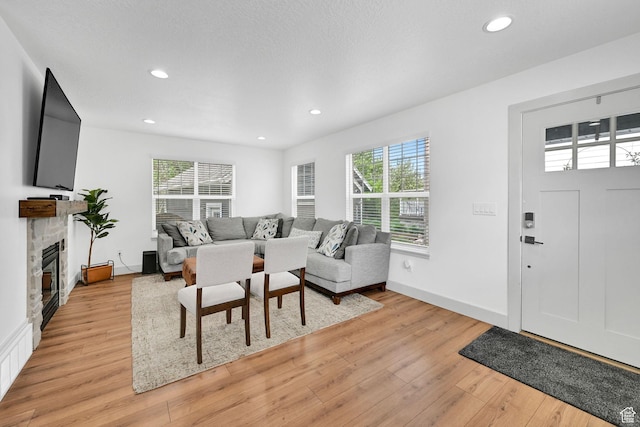 3553 N Willow Creek Ln E, Eden, UT 84310 - living room with healthy amount of natural light, light wood-type flooring, a stone fireplace, recessed lighting, and baseboards