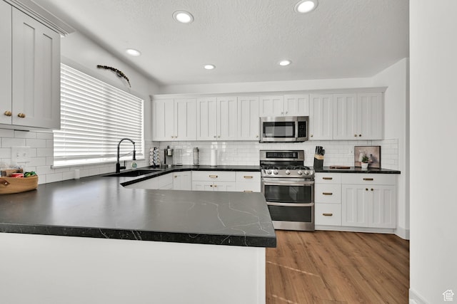 3553 N Willow Creek Ln E, Eden, UT 84310 - kitchen featuring appliances with stainless steel finishes, a sink, dark countertops, backsplash, and recessed lighting