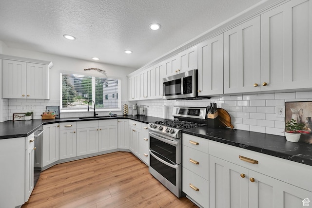 3553 N Willow Creek Ln E, Eden, UT 84310 - kitchen with appliances with stainless steel finishes, a sink, recessed lighting, a textured ceiling, and light wood-style flooring