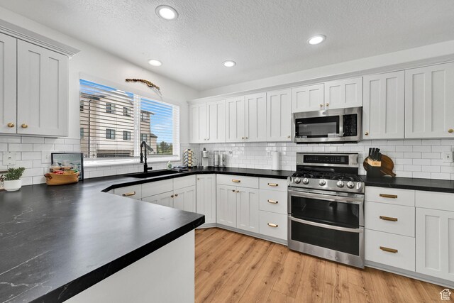 3553 N Willow Creek Ln E, Eden, UT 84310 - kitchen with appliances with stainless steel finishes, a sink, dark countertops, tasteful backsplash, and recessed lighting