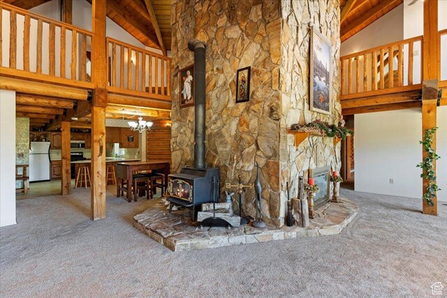 5375 N 3325 E, Eden, UT 84310 - unfurnished living room with high vaulted ceiling, carpet flooring, a wood stove, beam ceiling, and wooden ceiling