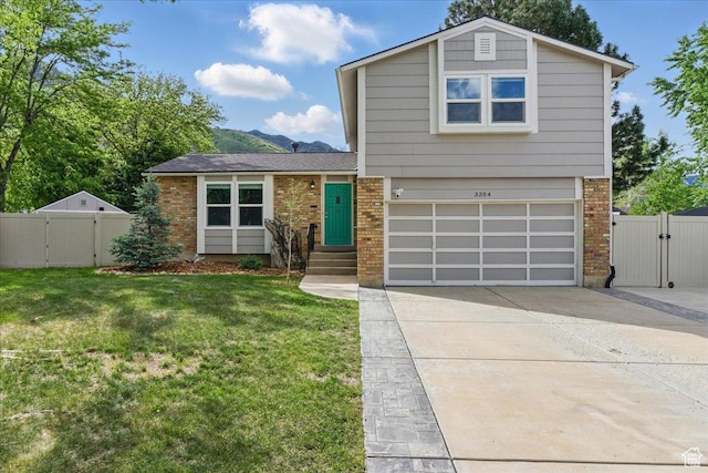view of front of property featuring a gate, brick siding, concrete driveway, and an attached garage