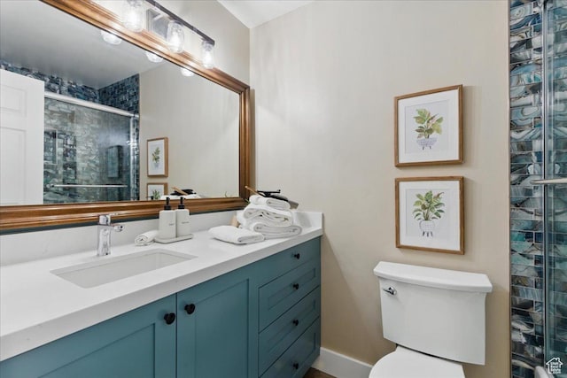 bathroom featuring a shower stall, vanity, and toilet