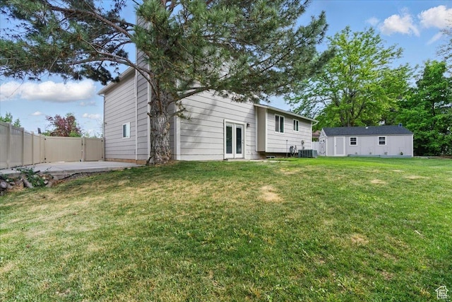 back of property featuring french doors, a patio area, cooling unit, and an outbuilding