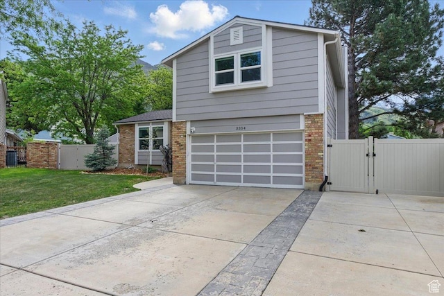 view of front facade with a gate, brick siding, concrete driveway, and an attached garage