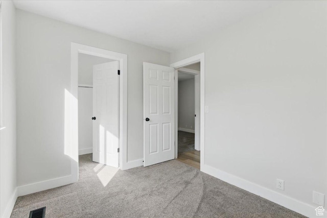 unfurnished bedroom featuring carpet flooring, baseboards, and a closet