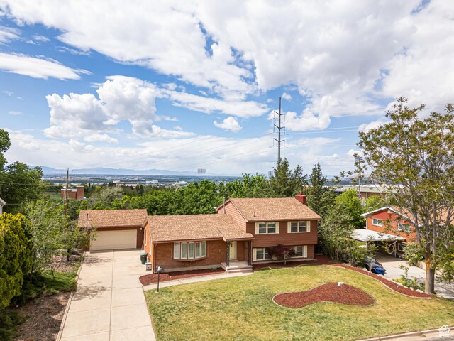 4115 Edgehill Dr, Ogden, UT 84403 - split level home with driveway, a garage, a front yard, and a chimney