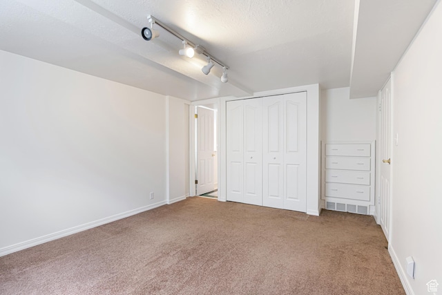 4115 Edgehill Dr, Ogden, UT 84403 - unfurnished bedroom with carpet flooring, rail lighting, baseboards, a textured ceiling, and a closet