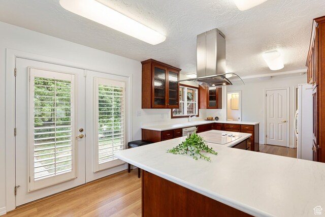4115 Edgehill Dr, Ogden, UT 84403 - kitchen featuring island exhaust hood, light wood-style floors, french doors, light countertops, and a textured ceiling