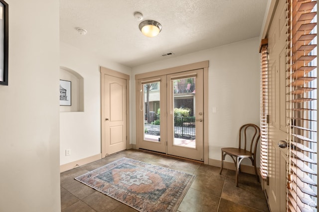 3702 S Arbroath Ln, South Salt Lake, UT 84115 - entryway featuring a textured ceiling, tile patterned floors, french doors, and baseboards
