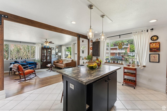 32 S Kingdon Ln E, North Salt Lake, UT 84054 - kitchen featuring light tile patterned floors, recessed lighting, pendant lighting, dark cabinetry, and baseboards