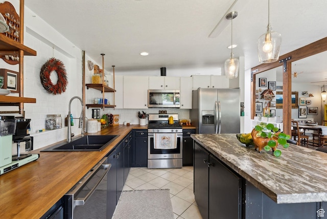 32 S Kingdon Ln E, North Salt Lake, UT 84054 - kitchen featuring stainless steel appliances, open shelves, a sink, wood counters, and light tile patterned floors