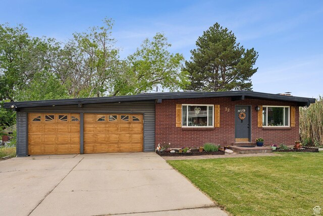 32 S Kingdon Ln E, North Salt Lake, UT 84054 - view of front of home with concrete driveway, an attached garage, a front yard, and brick siding