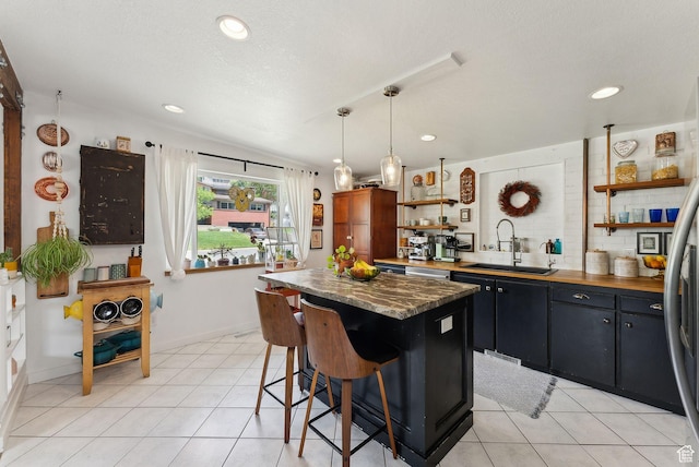 32 S Kingdon Ln E, North Salt Lake, UT 84054 - kitchen with open shelves, a sink, a center island, a kitchen bar, and light tile patterned floors