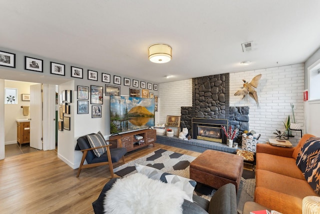 32 S Kingdon Ln E, North Salt Lake, UT 84054 - living area with light wood finished floors, a brick fireplace, baseboards, and brick wall
