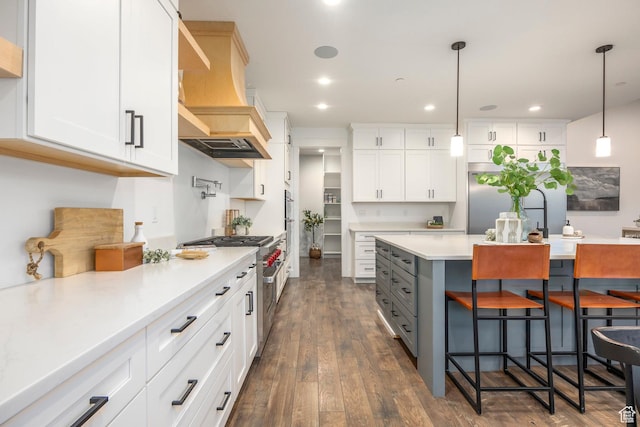 14943 S Auburn Sky Dr Unit 129, Draper, UT 84020 - kitchen featuring a kitchen bar, white cabinets, light countertops, hanging light fixtures, and dark wood-type flooring