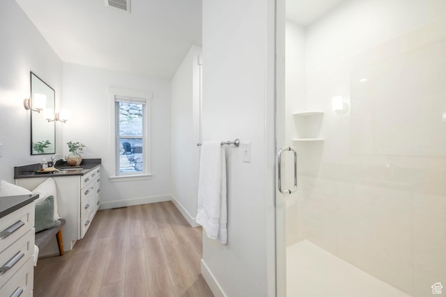 14943 S Auburn Sky Dr Unit 129, Draper, UT 84020 - full bath with wood finished floors, a stall shower, vanity, and baseboards
