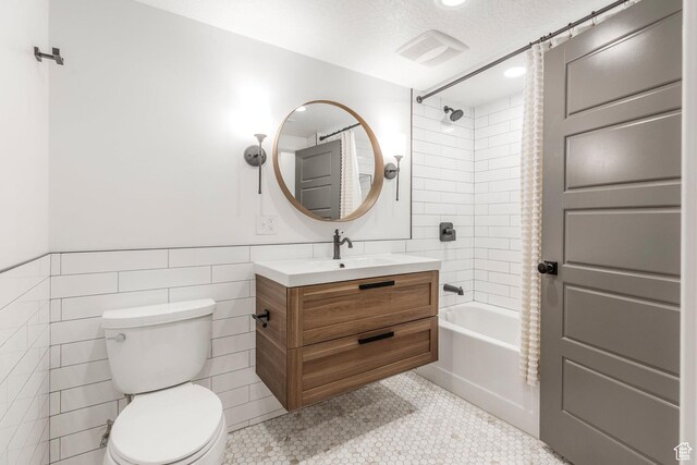 14943 S Auburn Sky Dr Unit 129, Draper, UT 84020 - bathroom with tile walls, shower / tub combo with curtain, vanity, a wainscoted wall, and tile patterned floors