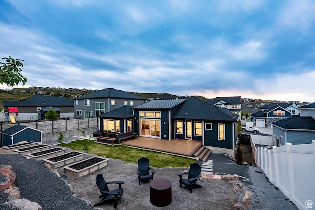 14943 S Auburn Sky Dr Unit 129, Draper, UT 84020 - rear view of property with a fire pit, a fenced backyard, a wooden deck, a residential view, and a garden